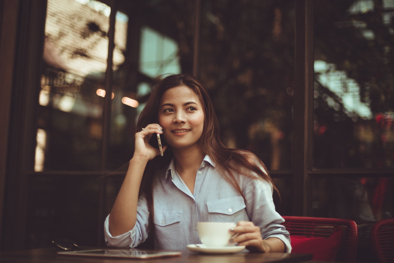 portrait-of-young-woman-using-mobile-phone-in-cafe-323503 (1)